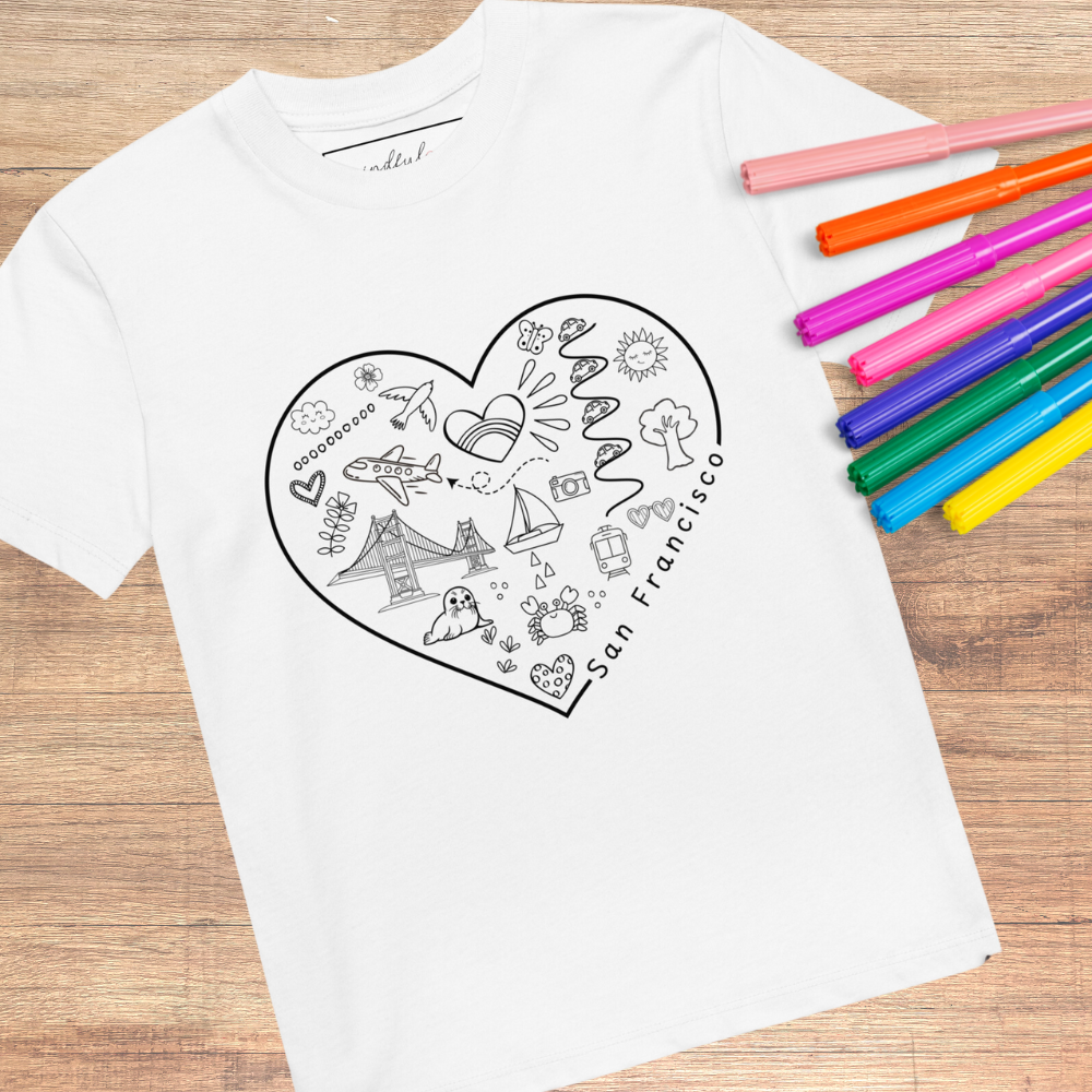 This San Francisco Color-in Tee by byKath.com is an organic cotton kids t-shirt that showcases a heart-shaped design filled with San Francisco-themed illustrations, including the Golden Gate Bridge and cable cars. It’s a part of the Interactive Kids Clothing line, encouraging creativity as it comes with colored markers beside it on a wooden surface.